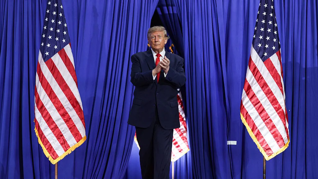 President Trump arriving between two American flags at a USDR event